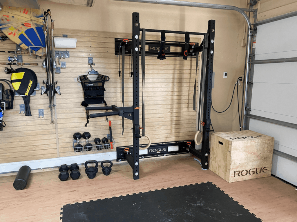 Rogue matador dip station attached to a Rogue foldable squat rack in a garage home gym