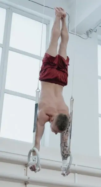 Gymnast performing handstand on rings