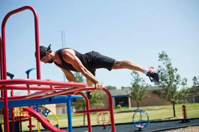 guy doing planche on outdoor fitness rails with shiny polyurethane coating