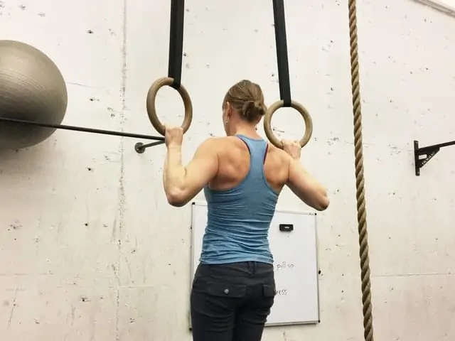 woman doing ring pull-up